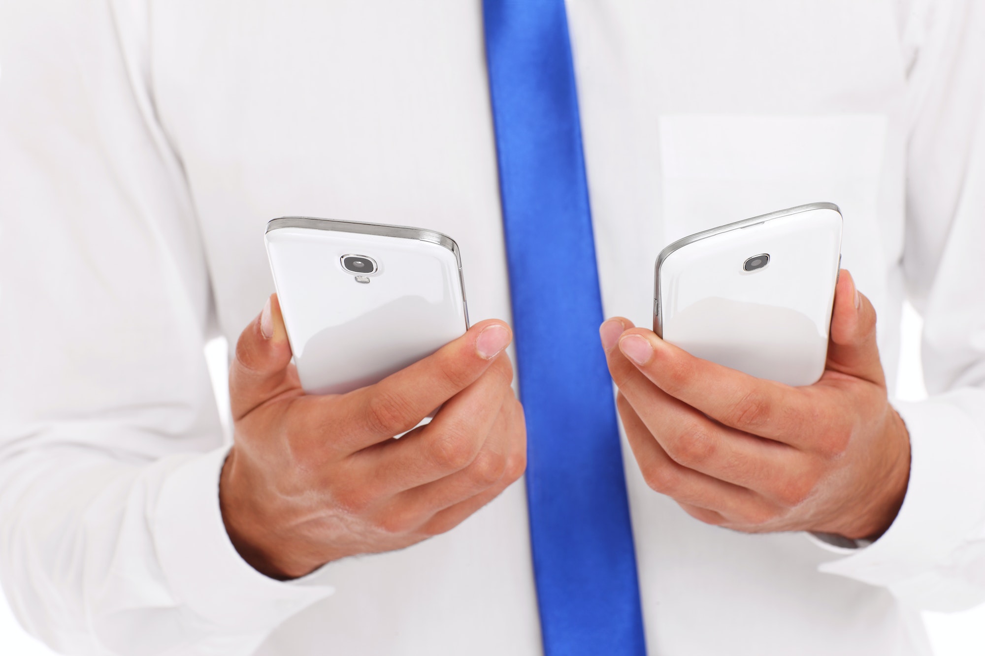 Midsection of businessman with two smarphones