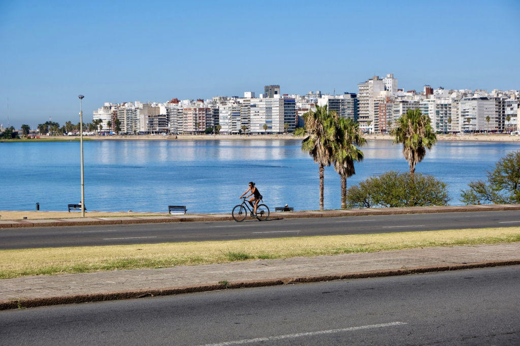 Woman biking along the coast of Montevideo, Uruguay in South America.