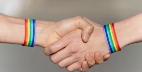 Close-up of a handshake with wristbands supporting the lgtbi movement.