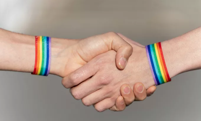 Close-up of a handshake with wristbands supporting the lgtbi movement.