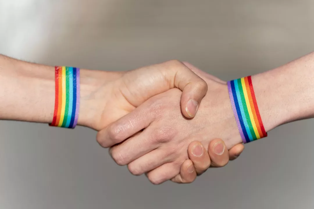 Close-up of a handshake with wristbands supporting the lgtbi movement.