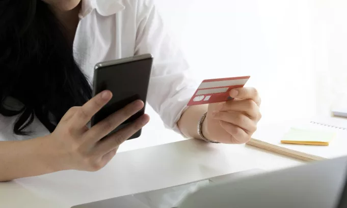 Online payment,woman's hands holding smartphone and using credit card for online shopping.