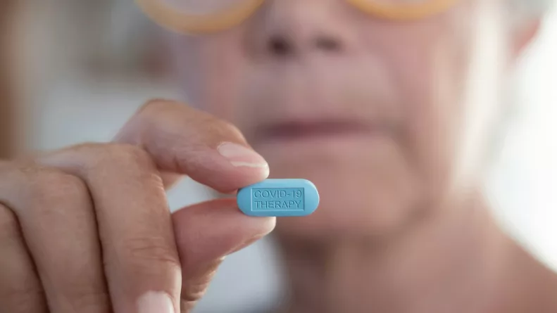 Female doctor holding the pill tablet for the fight against covid-19 coronavirus